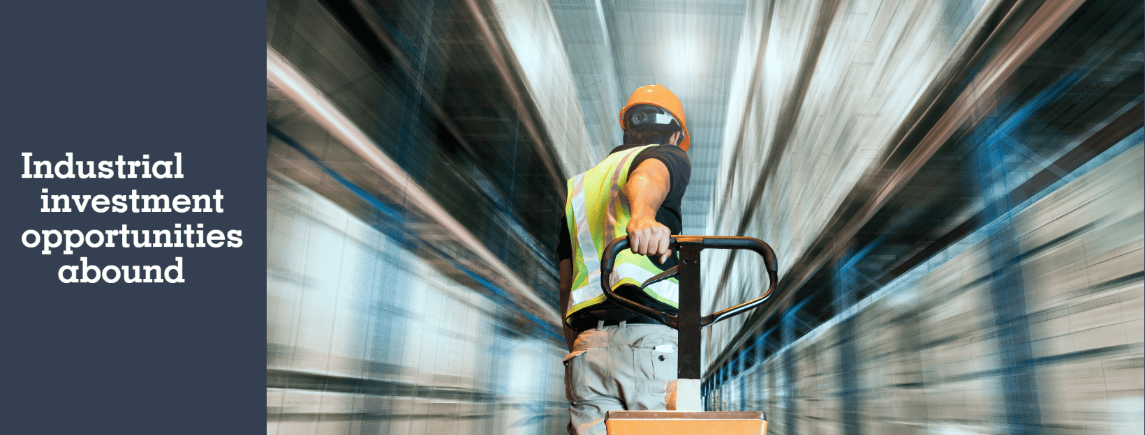 logistics worker pulls a pallet cart through a warehouse, the shelves on either side are blurred, implying he is moving at a high speed